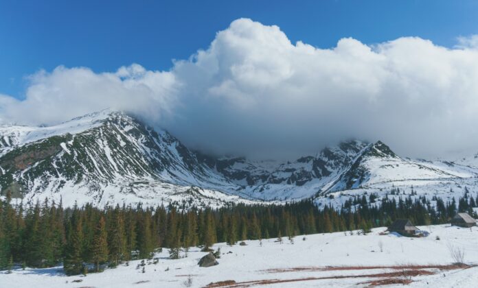 snow covered mountain under white clouds and blue sky during daytime