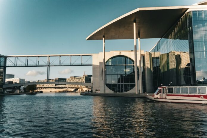 a boat traveling down a river next to a tall building
